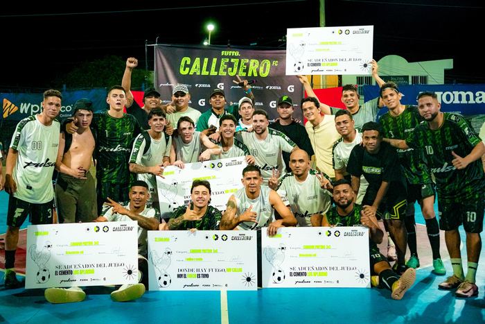 El equipo campeón levanta los pergaminos frente a la valla de Callejero, de noche y sobre la cancha azul