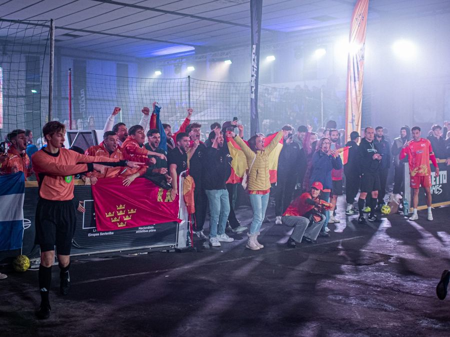 Un equipo celebrando dentro de la cancha con la bandera de su país en alto