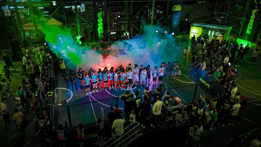 Los equipos entran a la cancha entre humo verde y rojo, con la gente alrededor de la reja